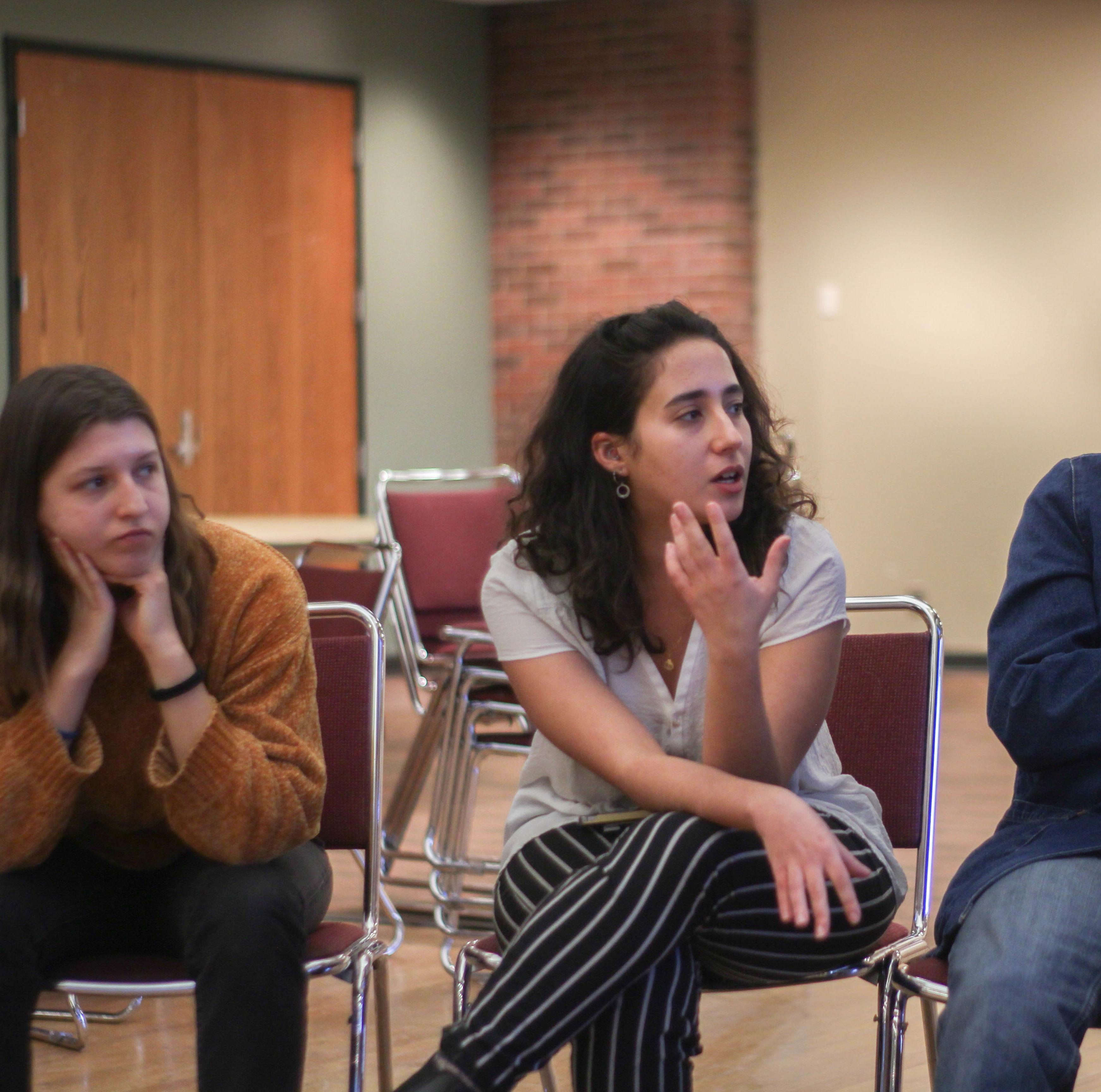 students sit in a discussion circle for a panel event called "Beyond Borders"